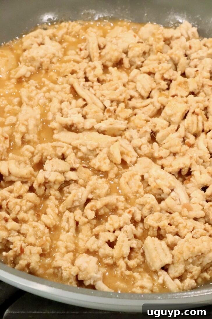 cooked ground chicken in a skillet covered with a miso ginger sauce